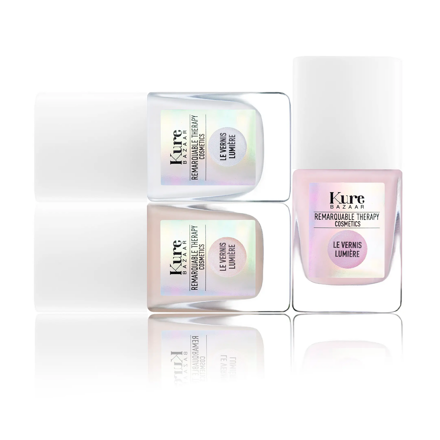 Three Kure Bazaar nail polish bottles with iridescent labels on a white background