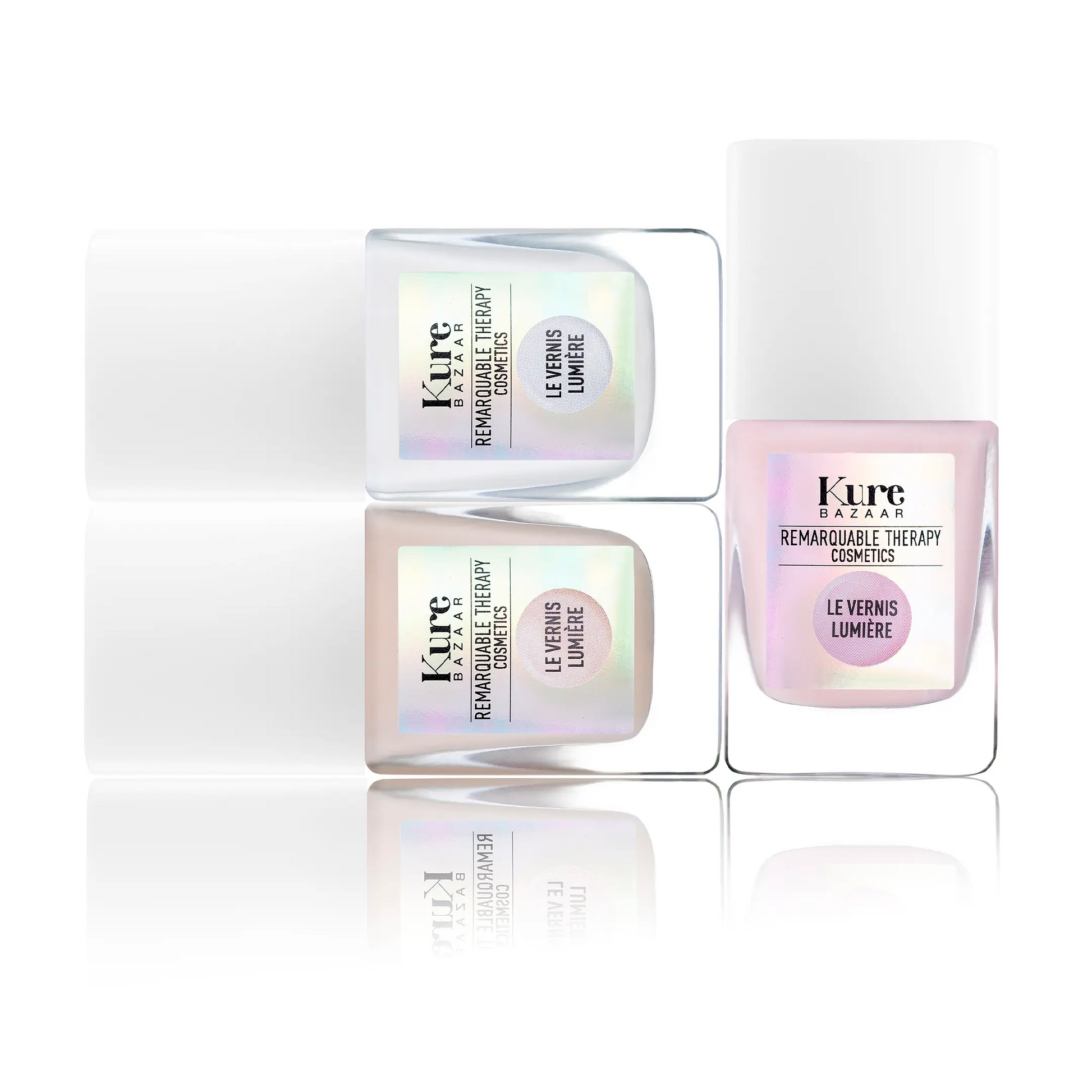Three Kure Bazaar nail polish bottles with iridescent labels on a white background