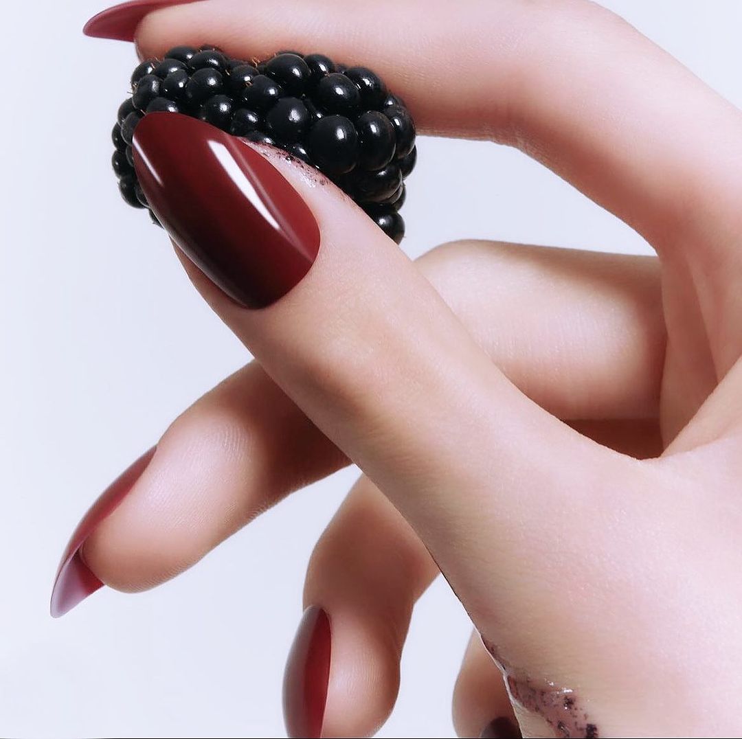 Picture of a hand with Kure Bazaar Cherie Non Toxic Nail Polish and a blackberry